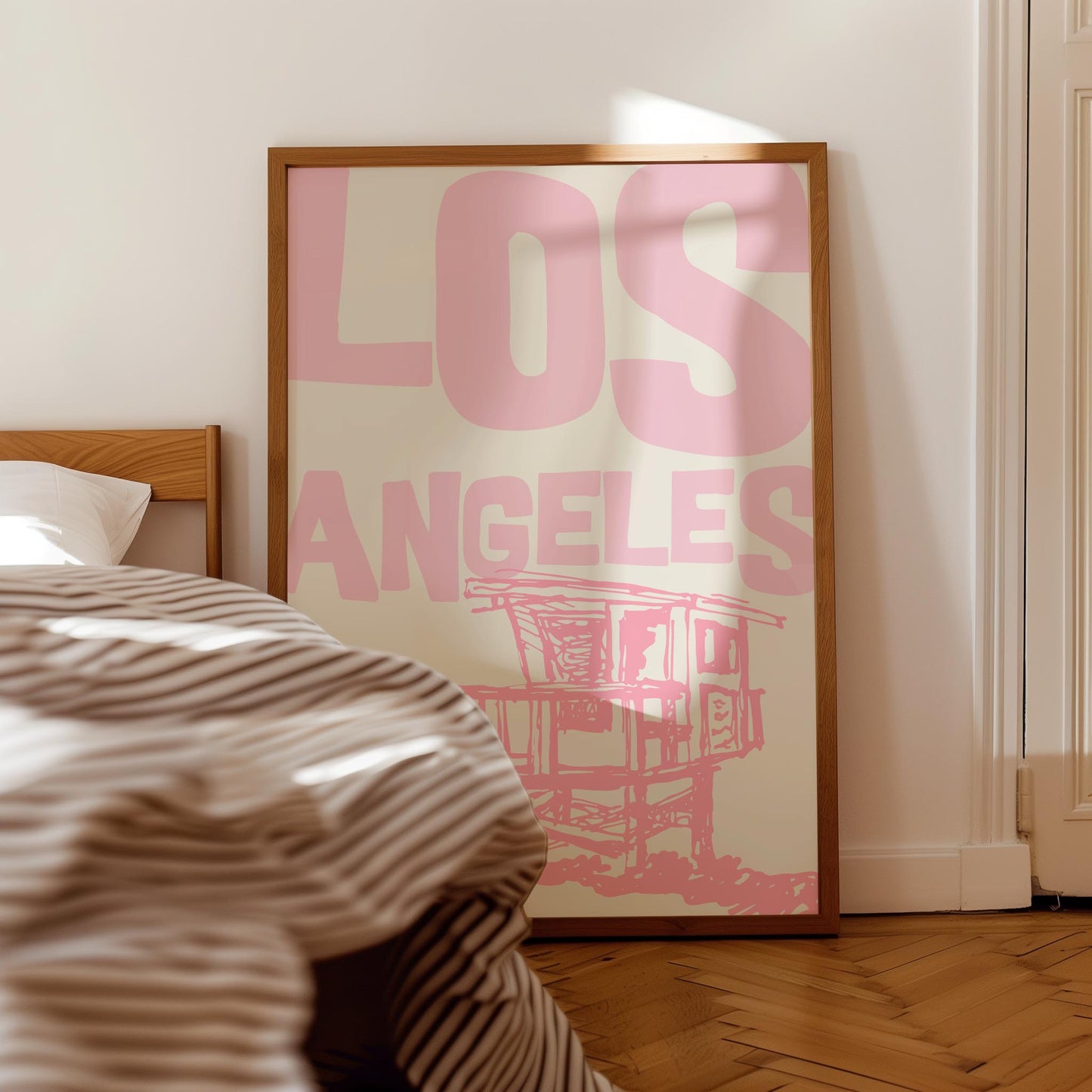 Printable Los Angeles travel poster in pastel pink. The wall art features a sketchy illustration of a beach lifeguard tower and bold text.