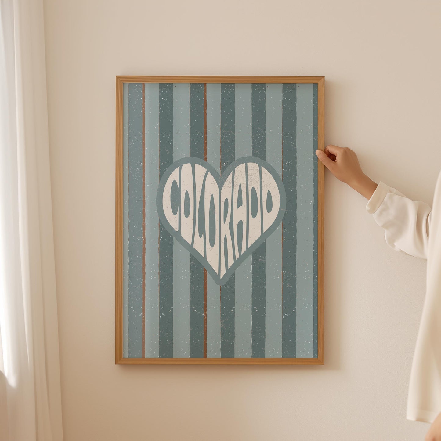 Colorado written in white text inside a heart shape on a background of vertical muted blue and brown stripes.