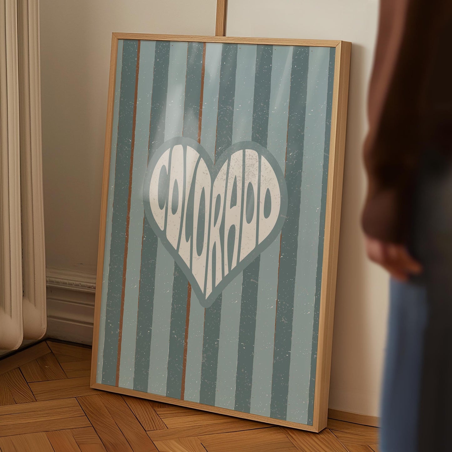Colorado written in white text inside a heart shape on a background of vertical muted blue and brown stripes.