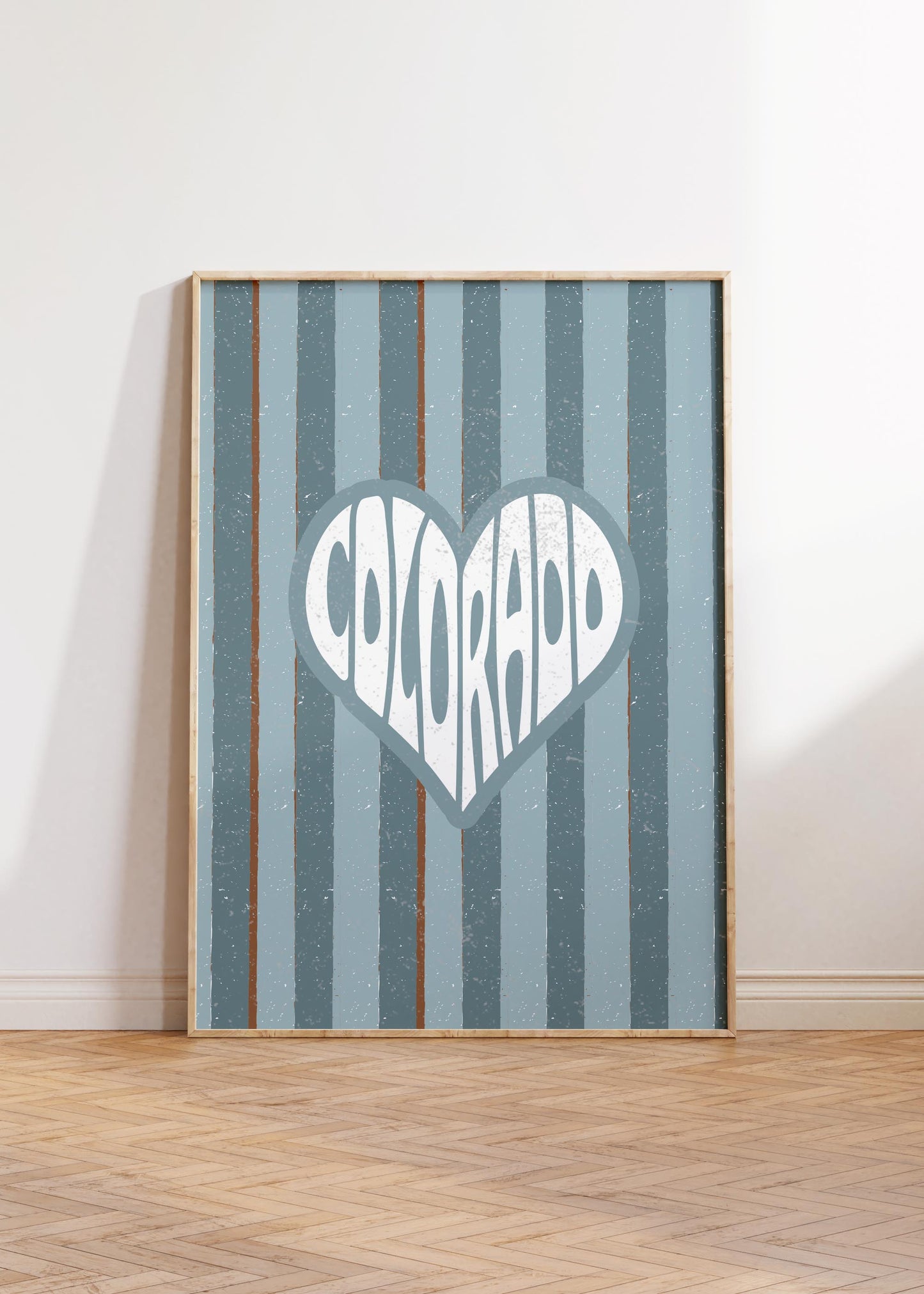 Colorado written in white text inside a heart shape on a background of vertical muted blue and brown stripes.