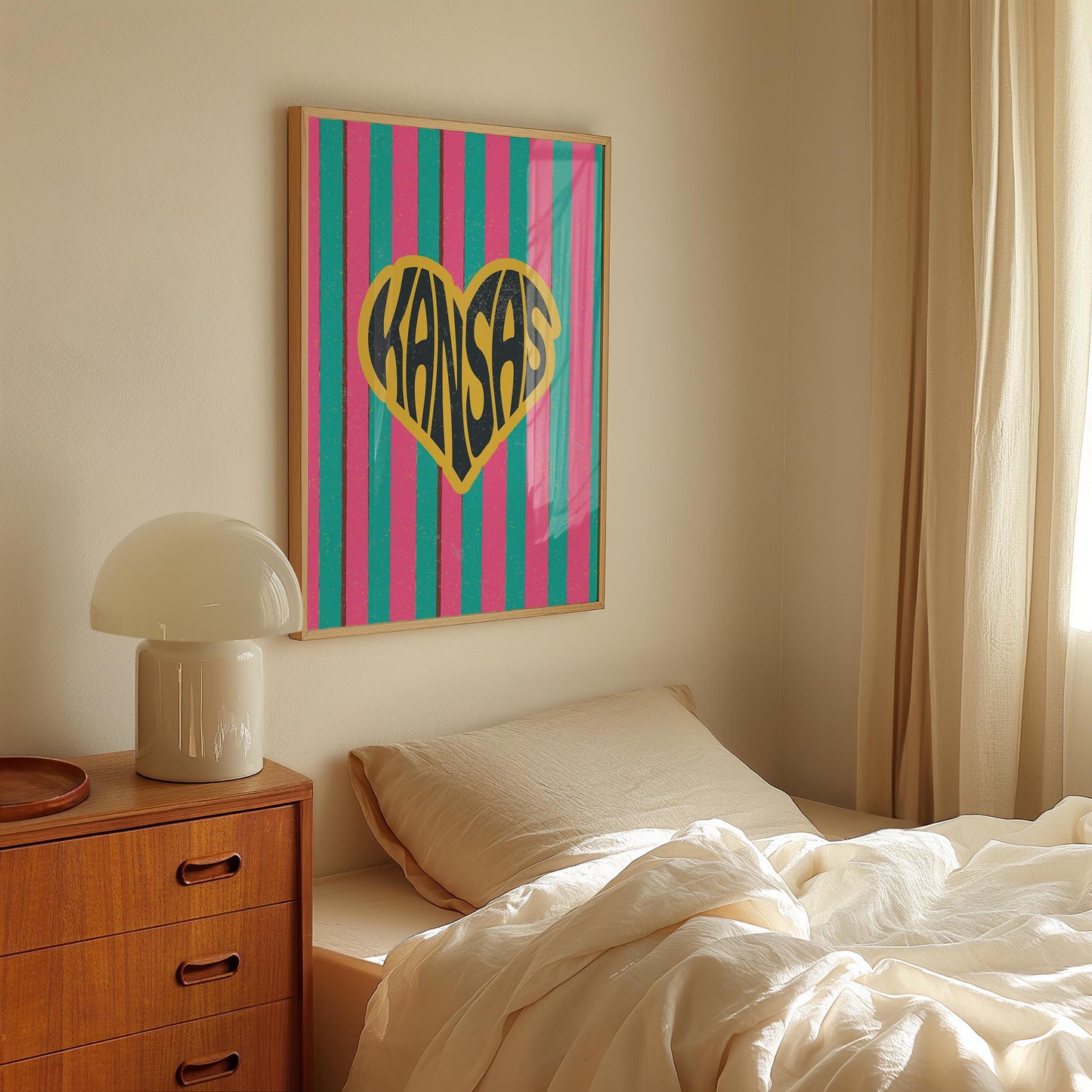 A heart-shaped design with the word 'Kansas' in groovy black retro font, outlined in yellow, set against a background of vertical pink and teal stripes.