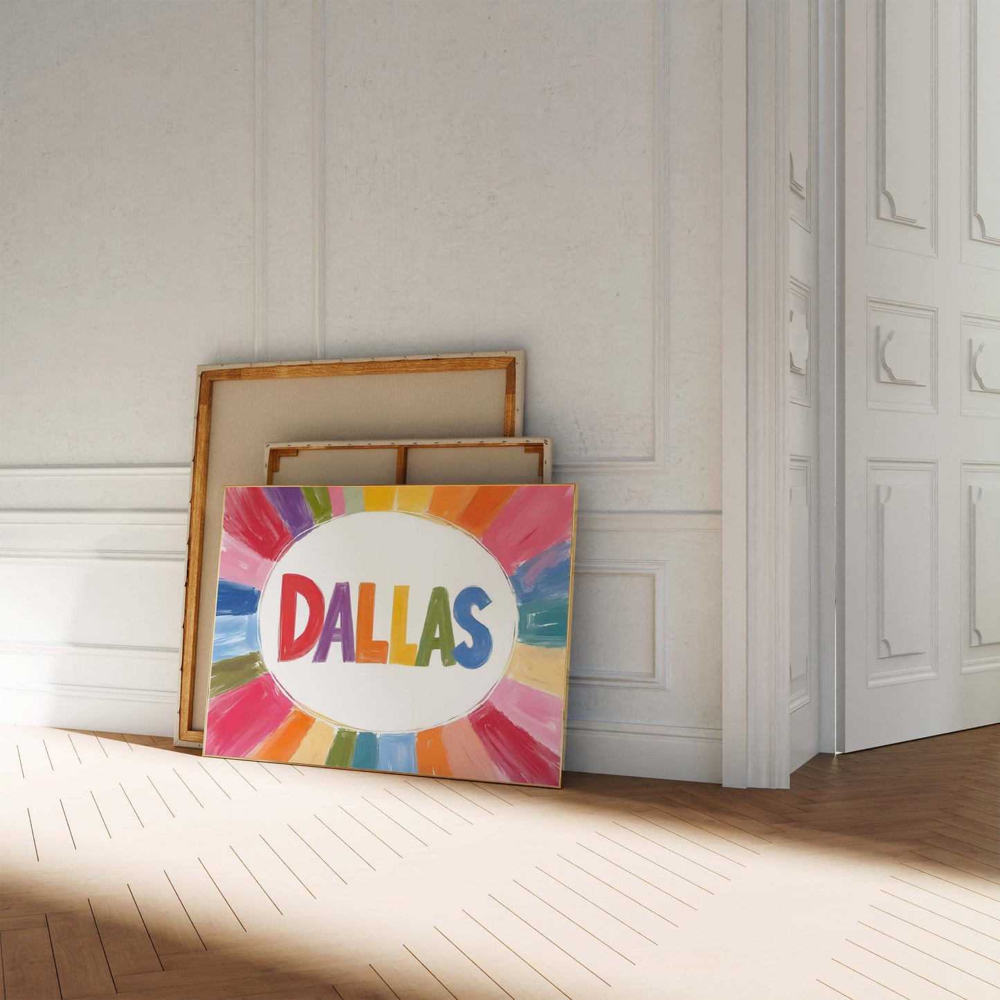 A colorful Dallas print in a landscape frame, with the word 'DALLAS' in rainbow letters surrounded by a painterly sunburst of color.