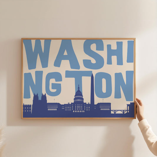 A modern graphic print of the Washington DC skyline, including the Capitol Building. The word 'WASHINGTON' is in large blue letters above the cityscape.