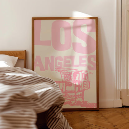 Printable Los Angeles travel poster in pastel pink. The wall art features a sketchy illustration of a beach lifeguard tower and bold text.
