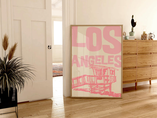 Printable Los Angeles travel poster in pastel pink. The wall art features a sketchy illustration of a beach lifeguard tower and bold text.