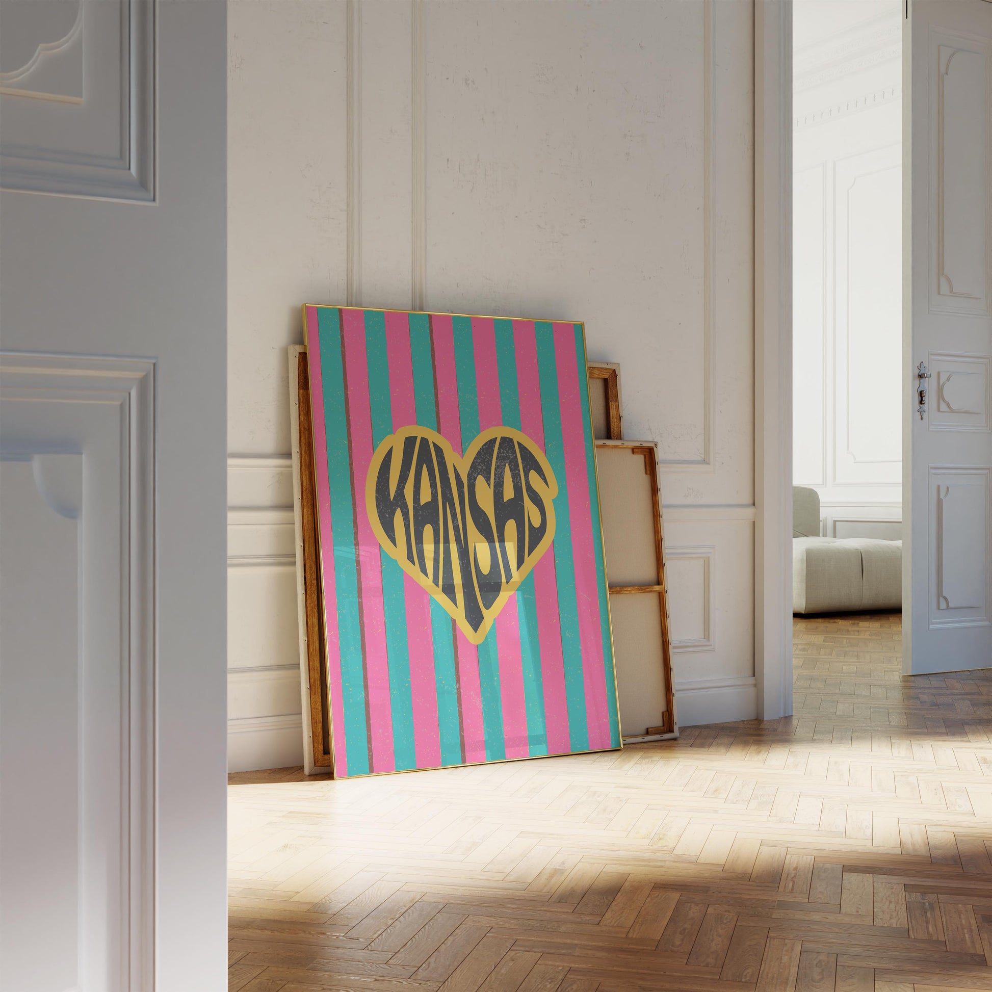 A heart-shaped design with the word 'Kansas' in groovy black retro font, outlined in yellow, set against a background of vertical pink and teal stripes.