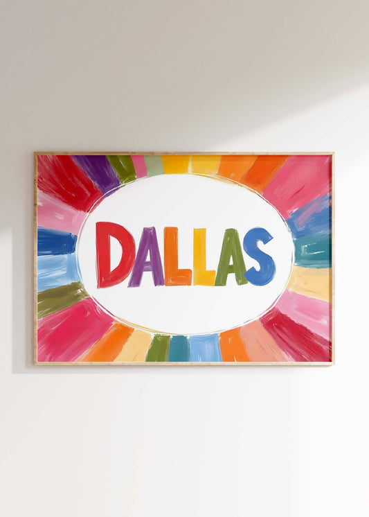 A colorful Dallas print in a landscape frame, with the word 'DALLAS' in rainbow letters surrounded by a painterly sunburst of color.