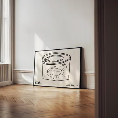 A minimalist line drawing of a tuna can, framed as kitchen wall art. The print includes the words 'fish' and 'still life'.