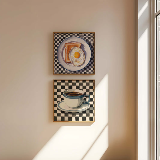 Two framed artworks on a wall, one with toast and an egg, the other with a coffee cup.